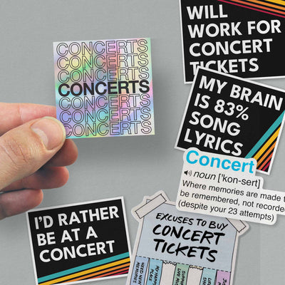 Hand holding three concert-themed vinyl stickers showcasing music quotes and designs.